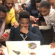 James Dennis, a 16-year-old graduating from TM Landry College Preparatory, nervously checks his application status with Yale as classmates watch on. (TM Landry College Prep via Facebook)